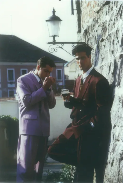 Két modell világos, kétsoros öltönyben egy kőfal előtt, 1993