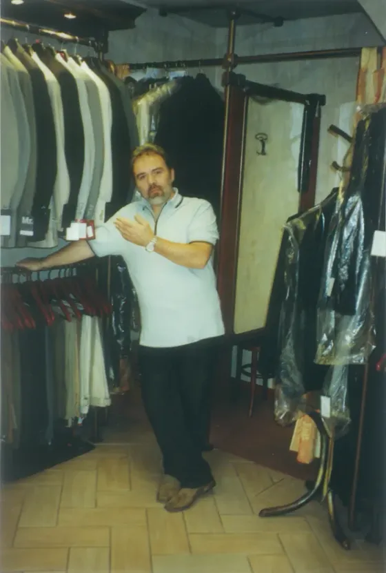 Az alapító az üzletben, öltönyállványok között, 2001